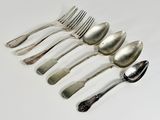 six spoons and a fork on a white surface