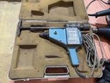 a blue drill in a case on a wooden table