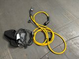 a yellow hose and a black bag on the floor