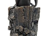 statue of a woman sitting on a tree stump with her hands on her hips