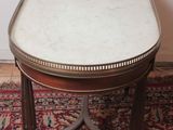 a small table with a marble top sitting on a rug