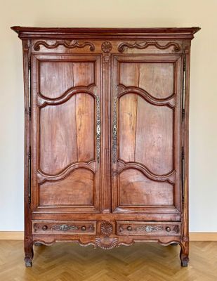 une armoire ancienne en bois dans une pièce avec un parquet