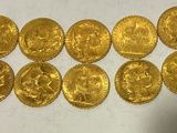 a bunch of gold coins sitting on top of a white surface