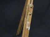an old wooden tripod with a paintbrush on top of it