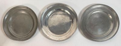 three silver metal trays sitting on top of a white table