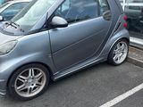 a smart car parked in a parking lot in front of a building
