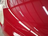 a close up of a red car ' s front bumper