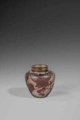 a brown and white vase sitting on top of a table
