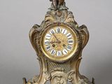 a gold clock with a little boy on top of it