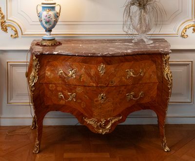 a marble topped chest of drawers with a vase on top