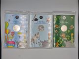 three children ' s books are lined up on a white surface