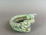 a close up of a green bracelet on a gray surface