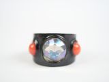 a close up of a black ring with an orange bead around it