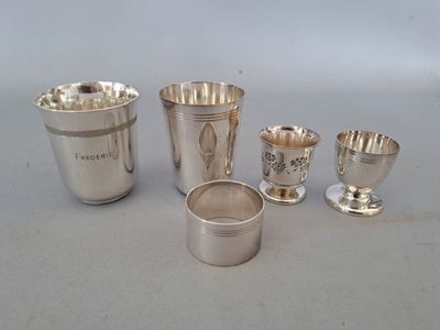 Plusieurs coupes et tasses en argent sont alignées sur une table
