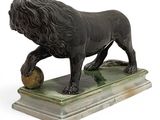 statue of a lion with a ball on a marble base