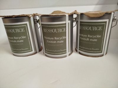 trois pots de peinture posés les uns à côté des autres sur un comptoir