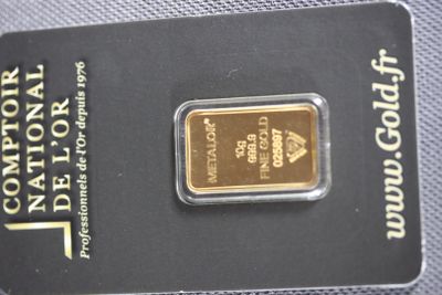 the gold bar is sitting on top of the card on the table