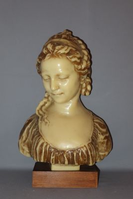 a statue of a woman with braid hair on a wooden stand