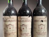 trois bouteilles de vin rouge posées côte à côte sur une table