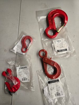 quelques crochets rouges et une paire de ciseaux par terre