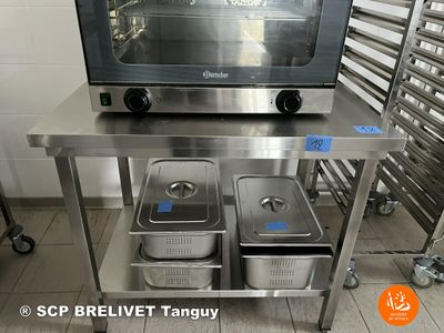 stainless steel table with three pans and a toaster oven on top