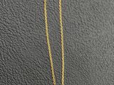 gold plated necklace with a black bead on a gold chain