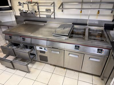 a large commercial kitchen with stainless steel appliances in it