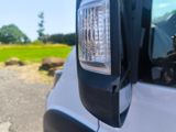 a close up of a car ' s headlight with a field in the background