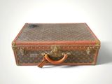 a brown and tan suitcase sitting on a white surface