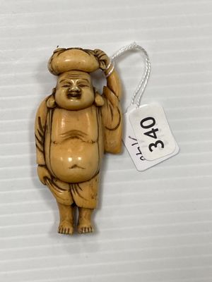une petite statue représentant un homme tenant un chapeau attaché à une ficelle