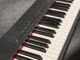a black piano with white and red keys sitting on a table