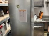 stainless steel refrigerator in a commercial kitchen with shelves and shelves