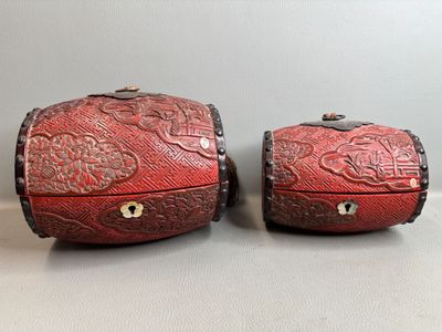 une paire de boîtes recouvertes de cuir rouge et ornées de motifs floraux