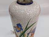 a white vase with blue and yellow flowers painted on it