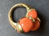 a gold ring with two orange stones on it