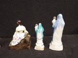 three figurines of jesus and a woman sitting on a rock