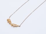 un collier en or orné d'un petit morceau de bois