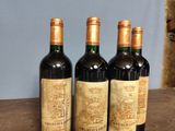 three bottles of wine sitting on top of a wooden table