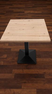 La table est en bois et possède un piètement en métal noir.