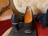 pair of black shoes sitting on top of a box next to a chair