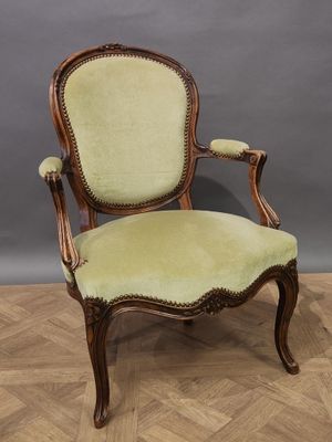 un fauteuil rembourré vert posé sur un parquet