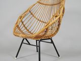 a close up of a rattan chair on a metal stand