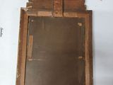 an old mirror with a wooden frame on a table