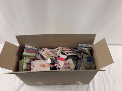 une boîte en carton remplie d'objets divers posée sur une surface blanche