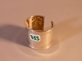 une bague en argent sur laquelle est collé un autocollant vert