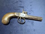 un gros plan d'un pistolet posé sur une table, avec une étiquette dessus