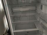 an empty refrigerator with its door open in a kitchen