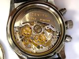 a close up of a watch and a coin on a table
