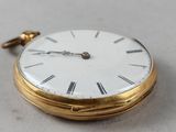 a gold pocket watch with roman numerals on the face