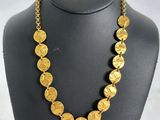 a necklace with gold coins on a mannequin
